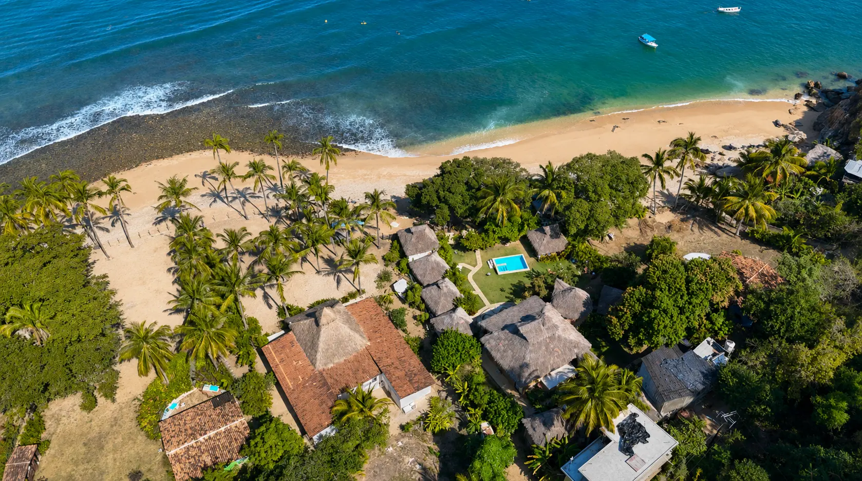 Vista aérea de Amaca Beach Retreat: palapas entre palmeras frente a la playa de Quimixto