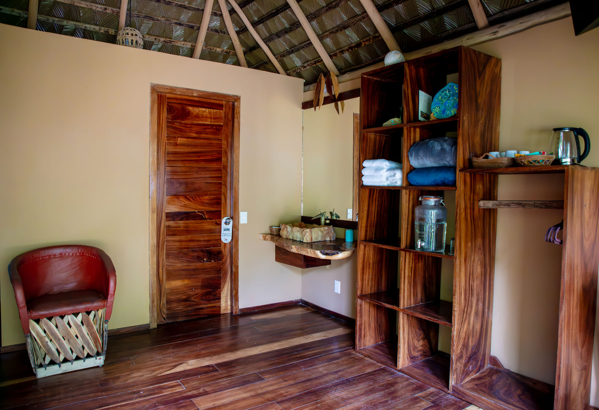 Palapa Suite: closet abierto de parota, lavabo de piedra natural y cafetera