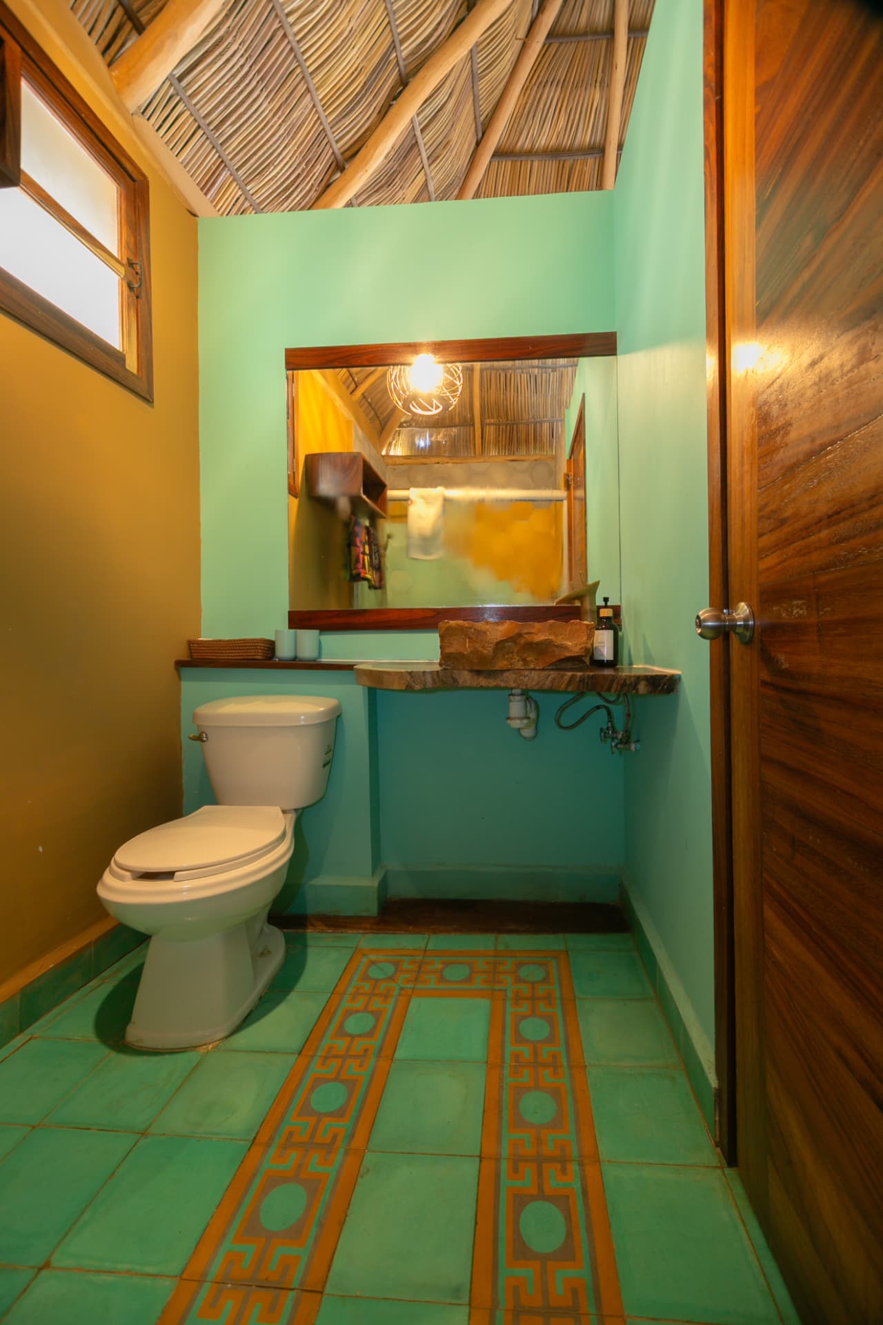 Alegría: baño con espejo, lavabo de piedra natural y mosaico artesanal
