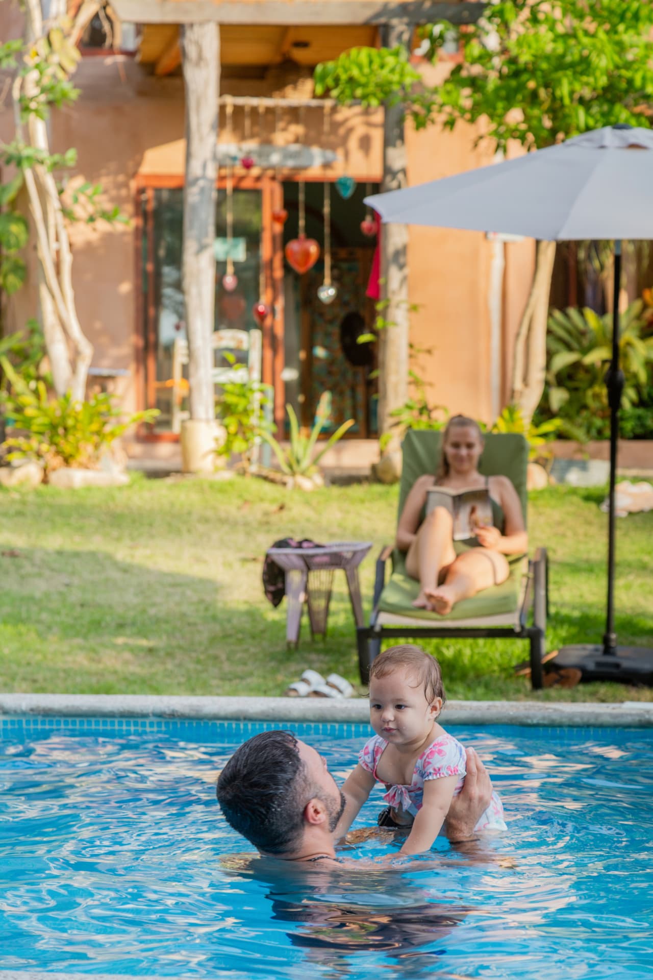 Father holding his baby in the Amaca Beach pool