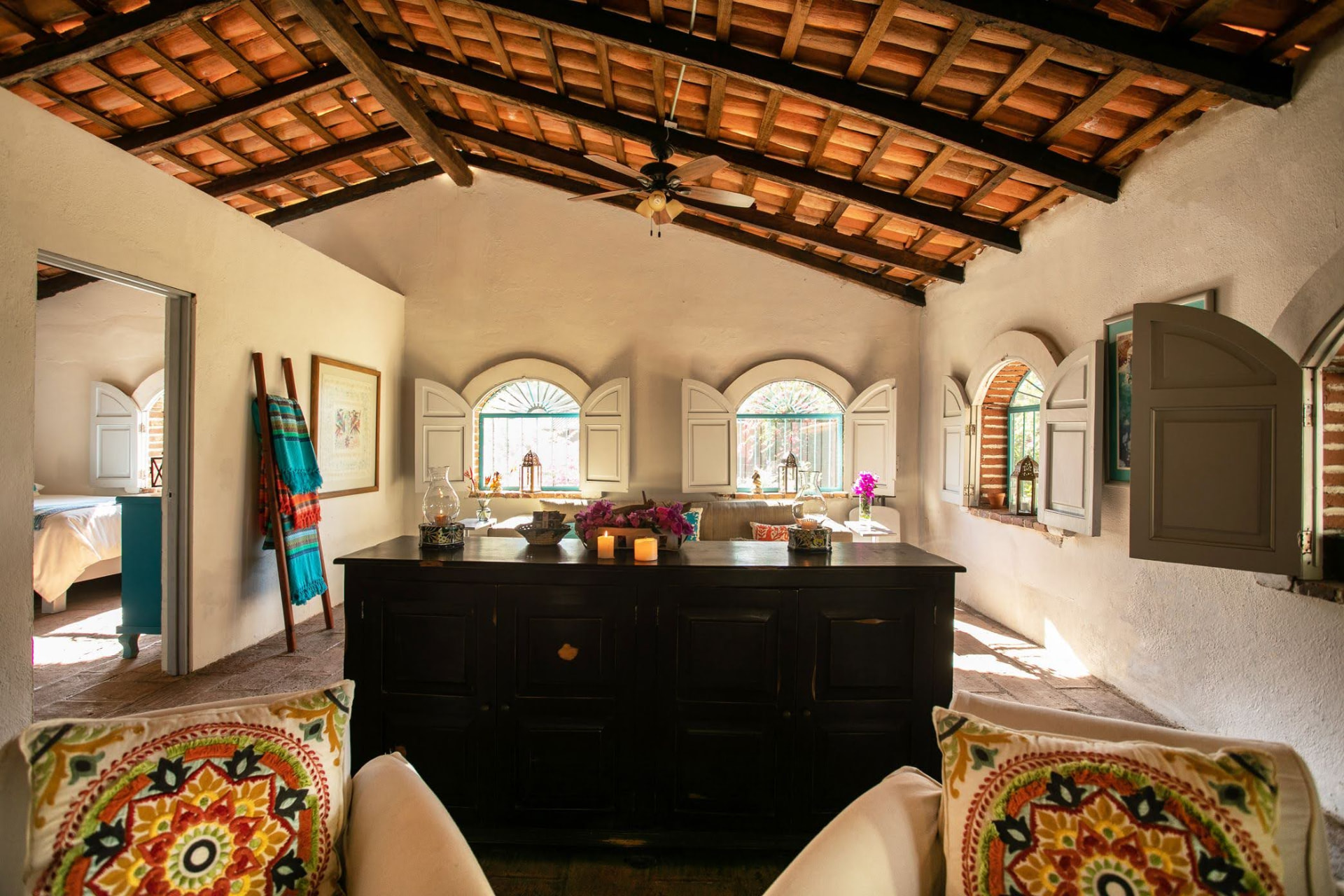 Villa: estancia con cómoda de madera y ventanales hacia el jardín