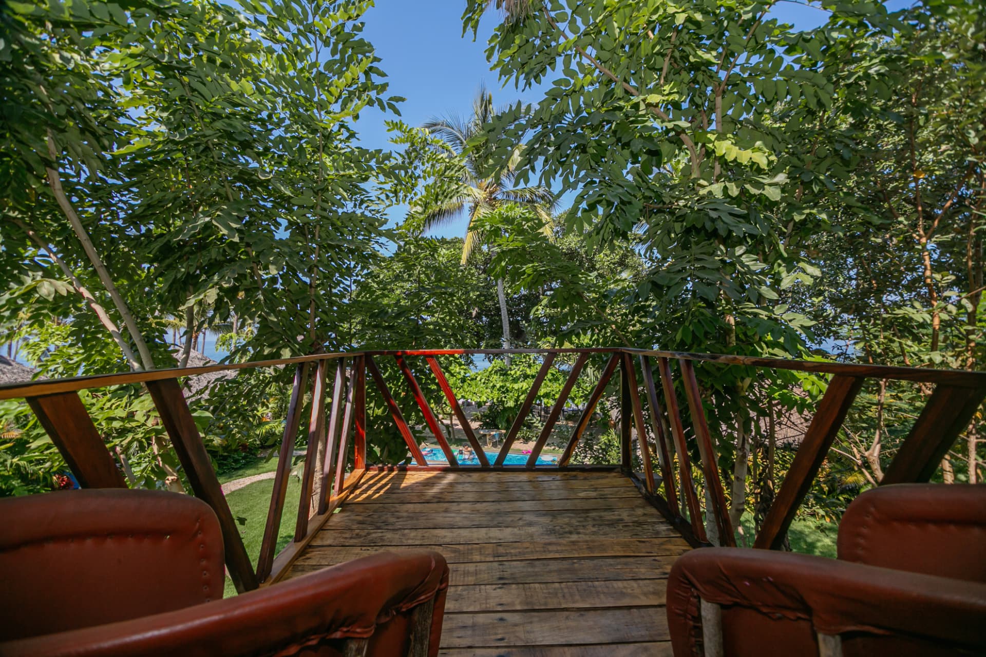Vista desde el balcón hacia la alberca, el jardín y el mar