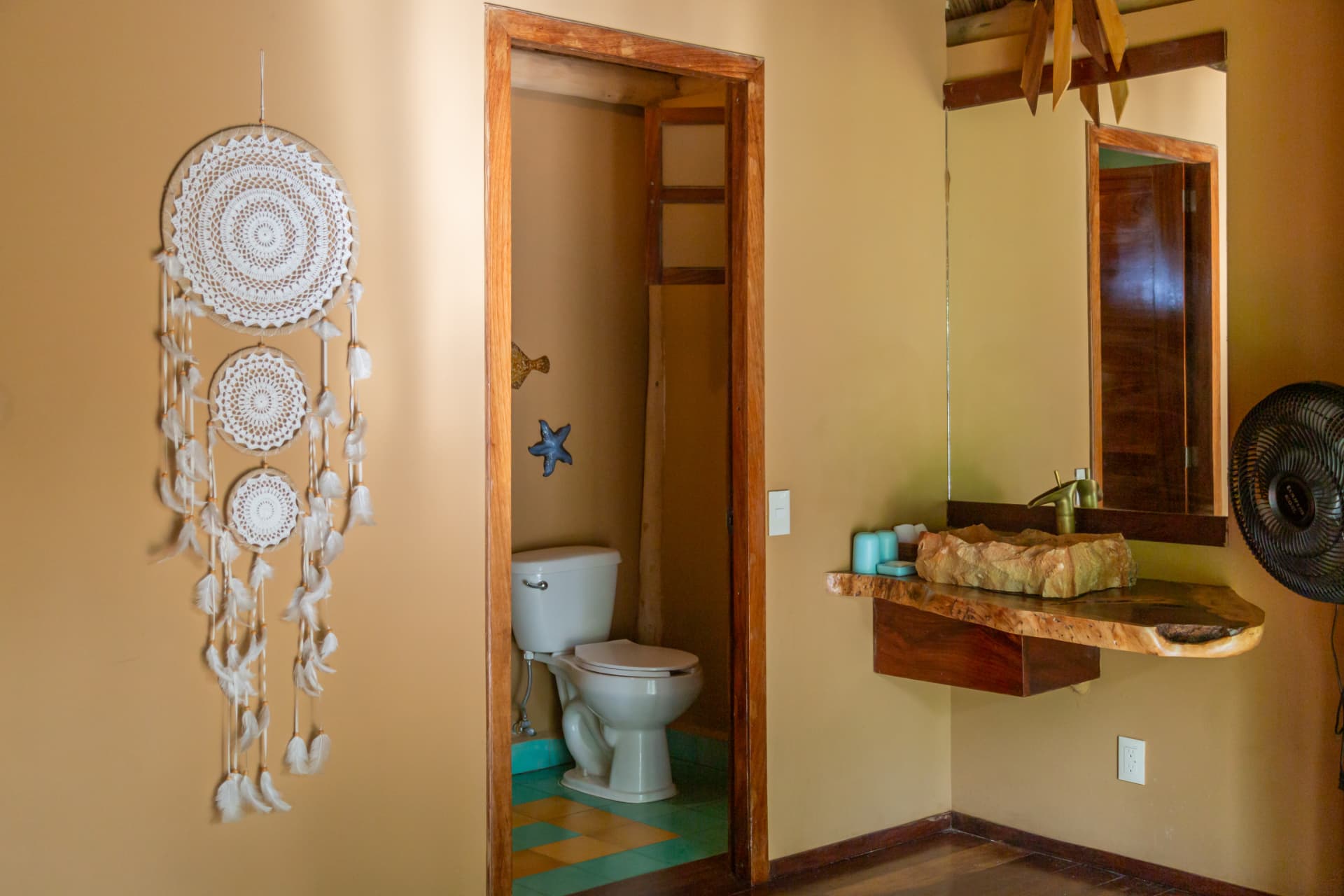 Palapa Suite: baño privado con lavabo de piedra, espejo y atrapasueños