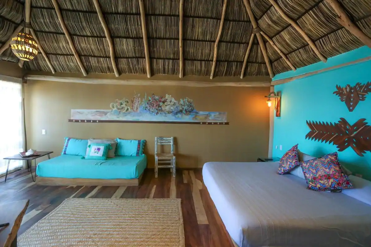 Sala de estar de la suite con sofá cama y arte mexicano