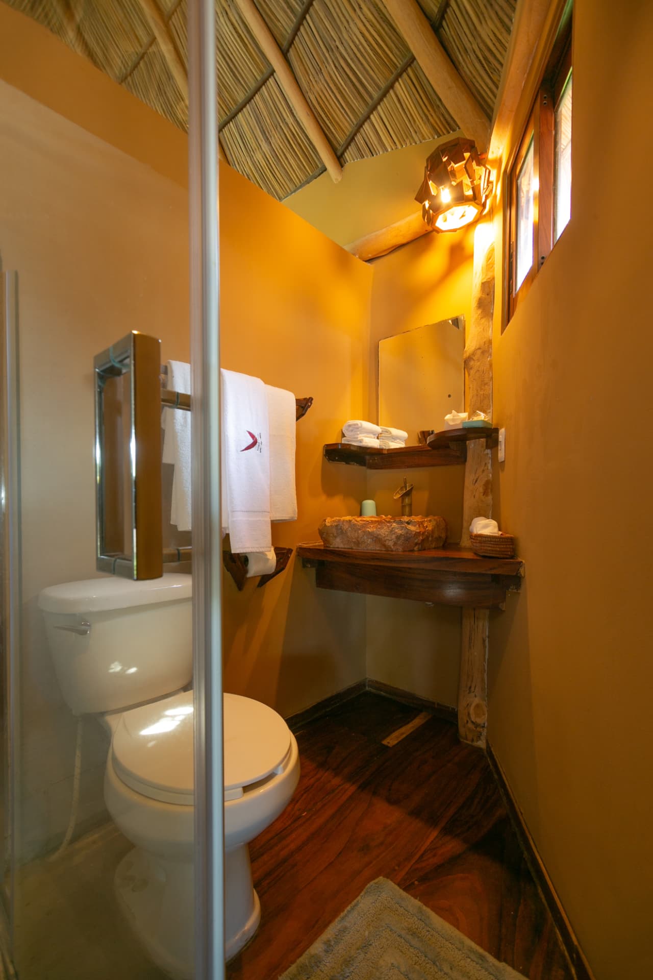Lavabo de piedra natural y toallas en el baño de la habitación