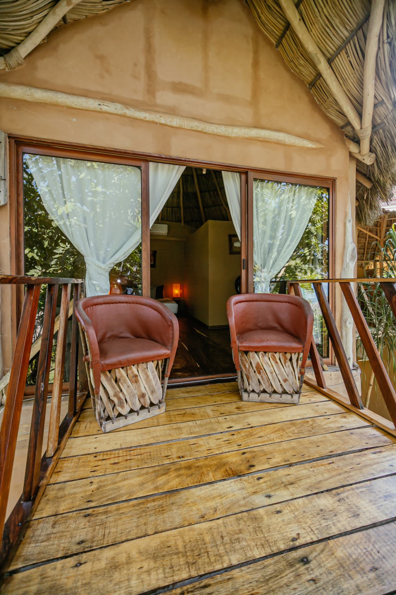 Terraza privada con sillones de cuero y piso de madera
