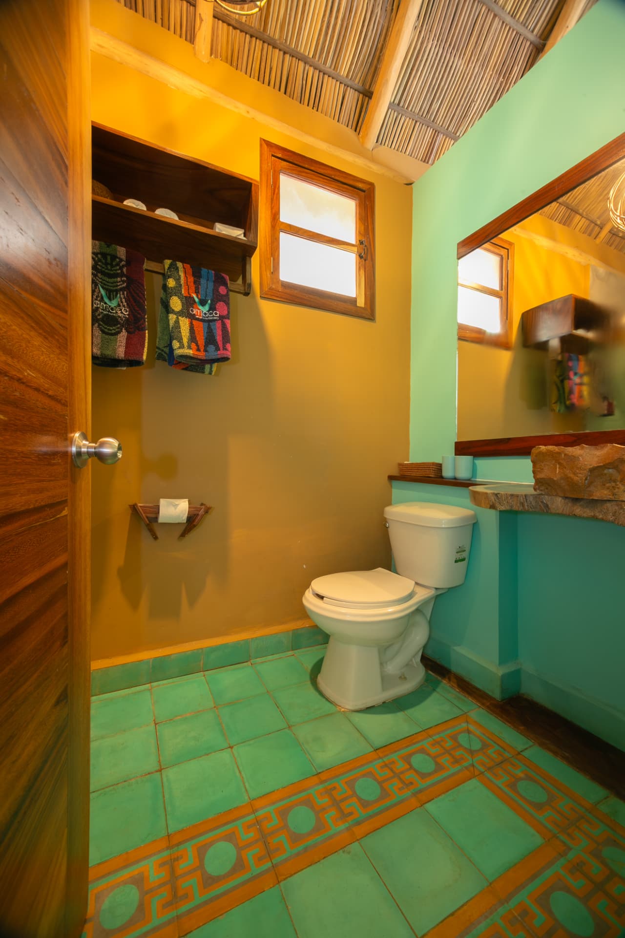 Alegría: baño privado con lavabo de piedra y piso de mosaico verde