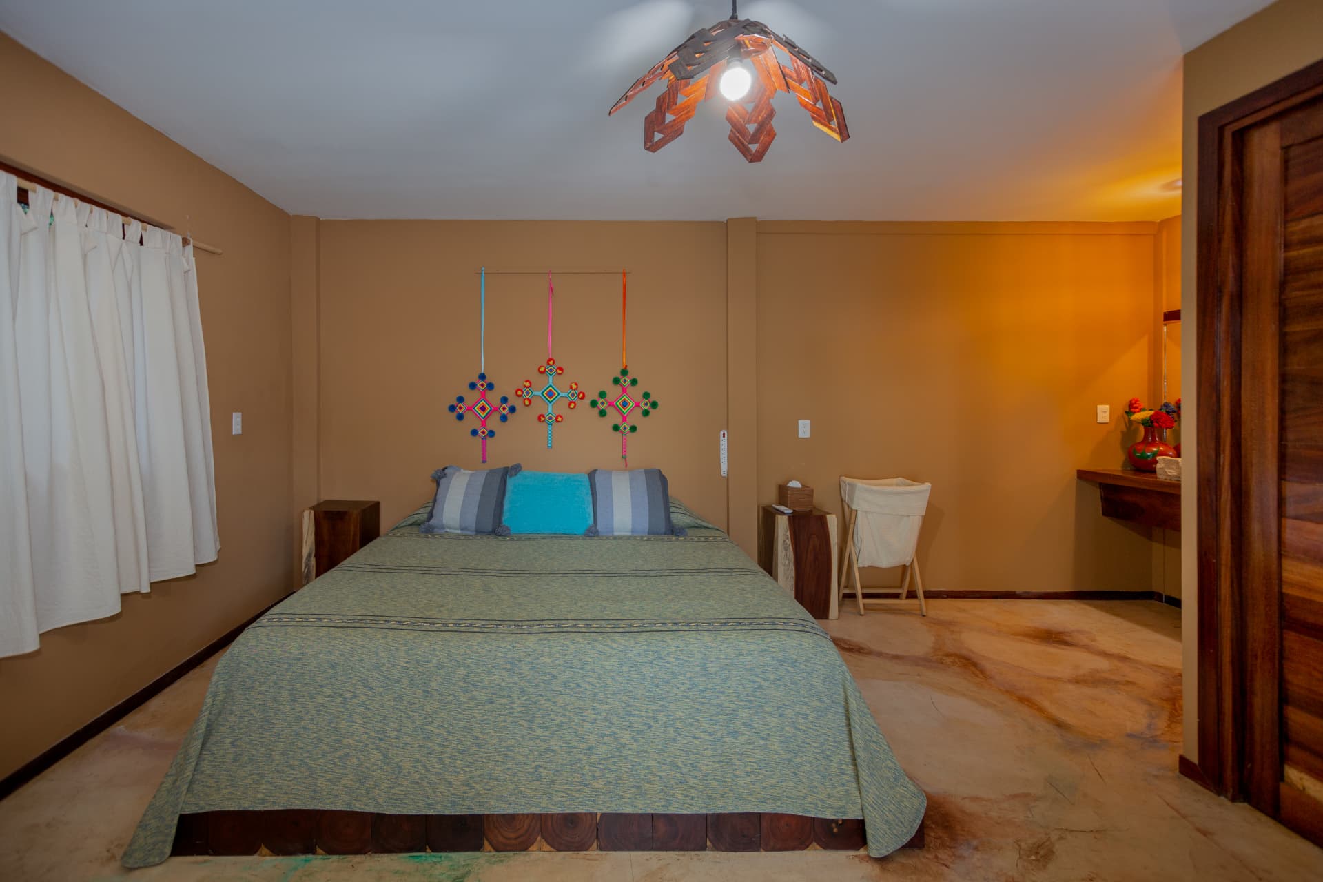 Agua: habitación con ventana, cortinas blancas y arte huichol