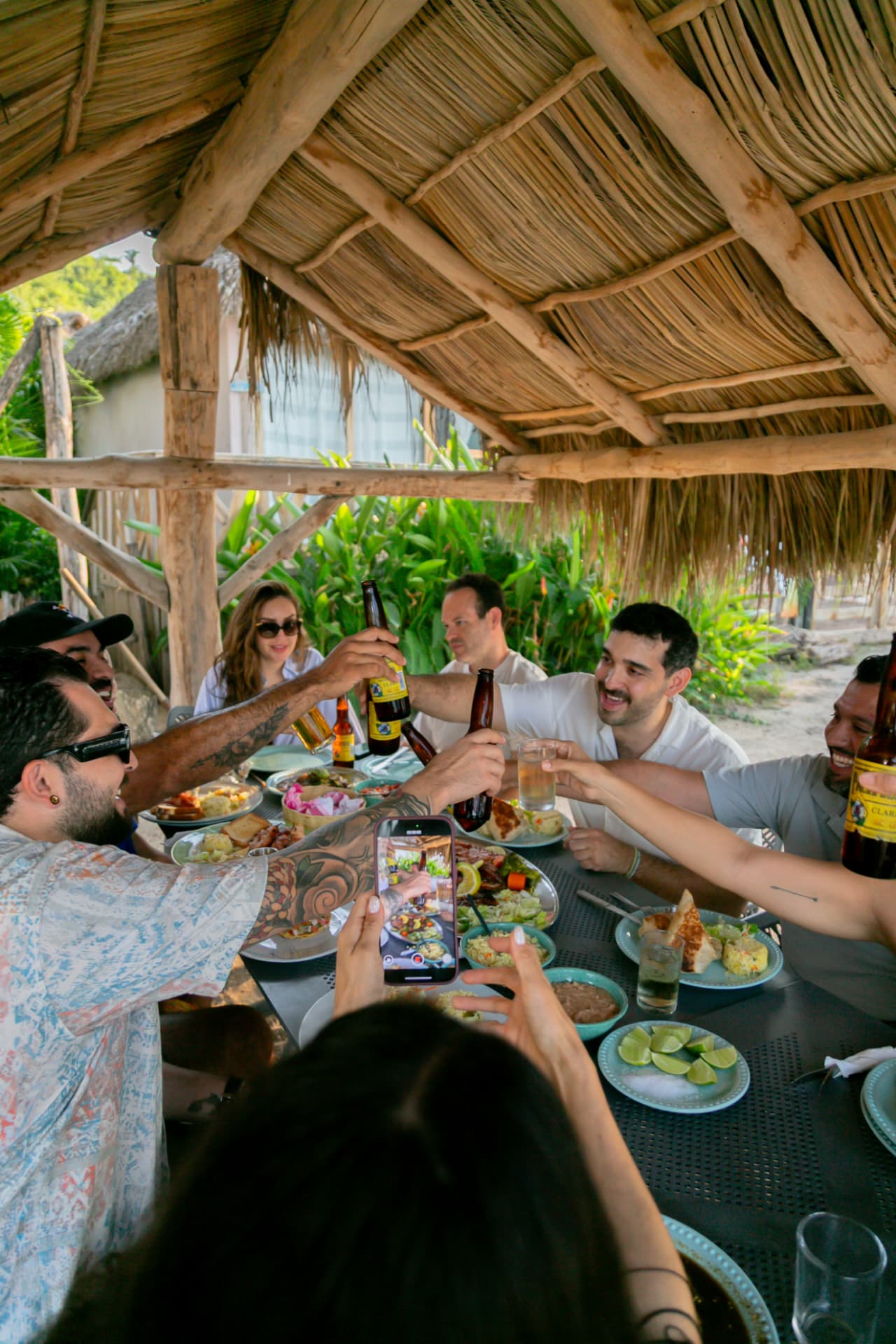 Friends toasting around the table at the beach club