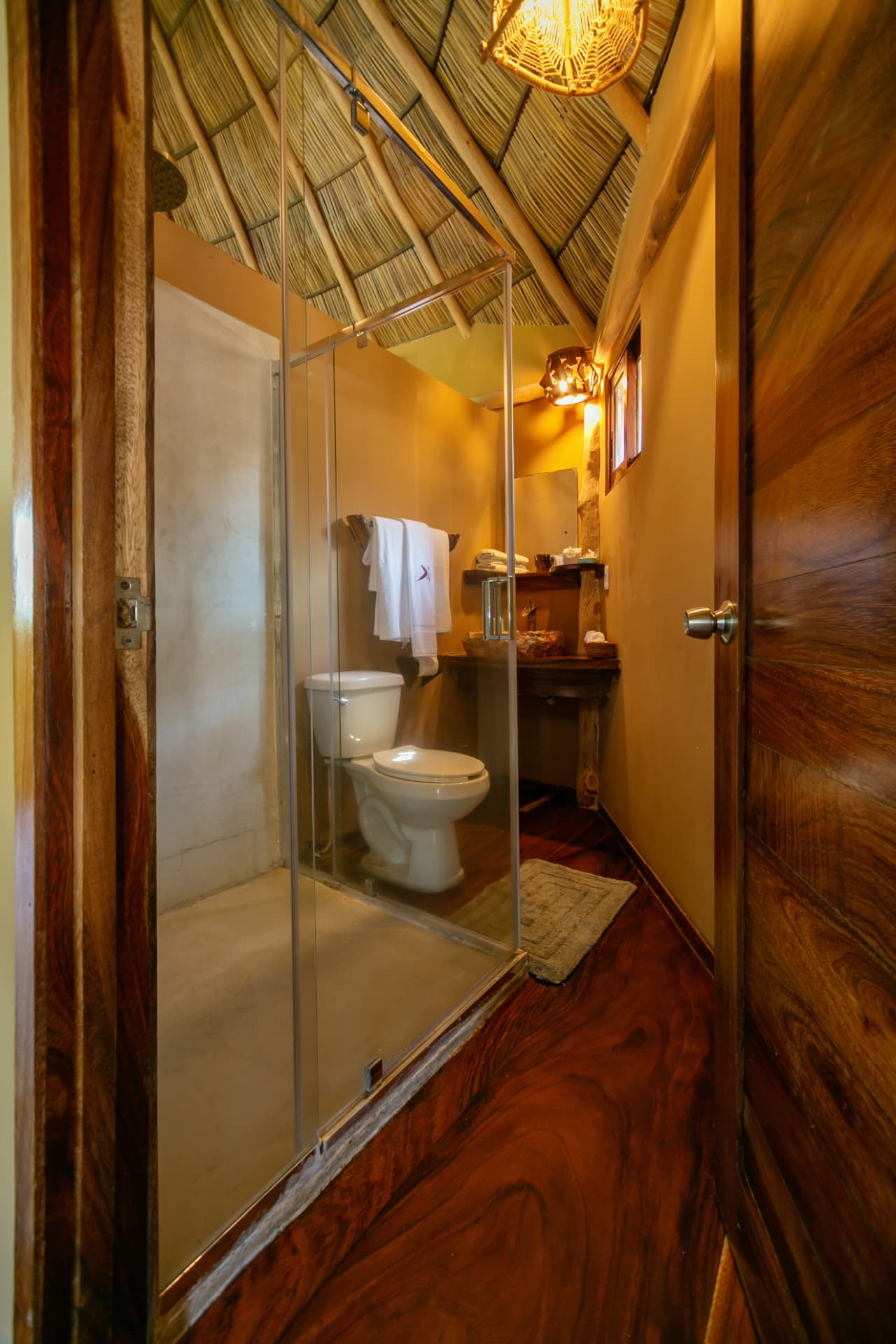Baño privado con ducha de lluvia y acabados de madera