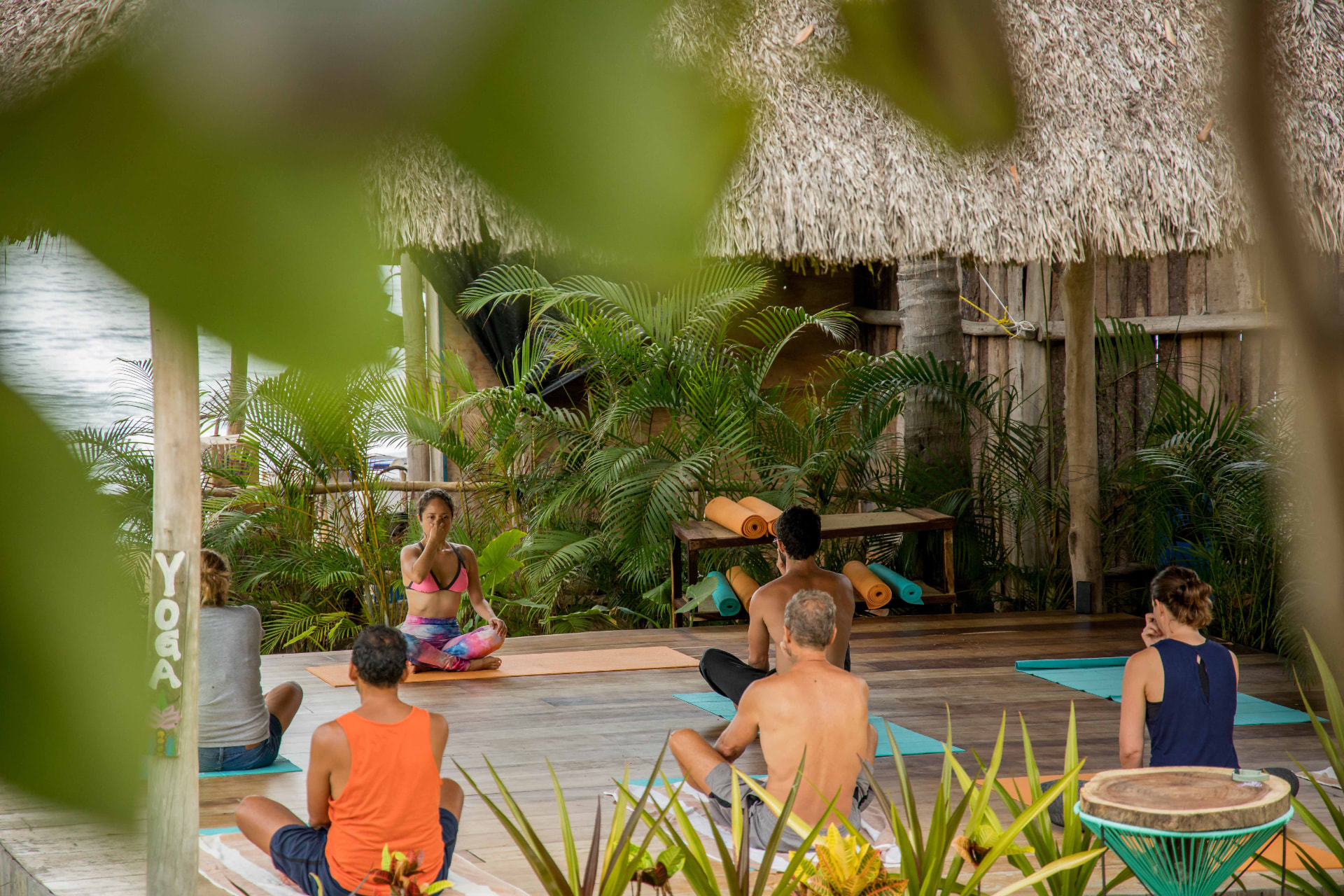 Clase de yoga en la palapa de La Xala, rodeada de vegetación tropical en Amaca Beach Retreat