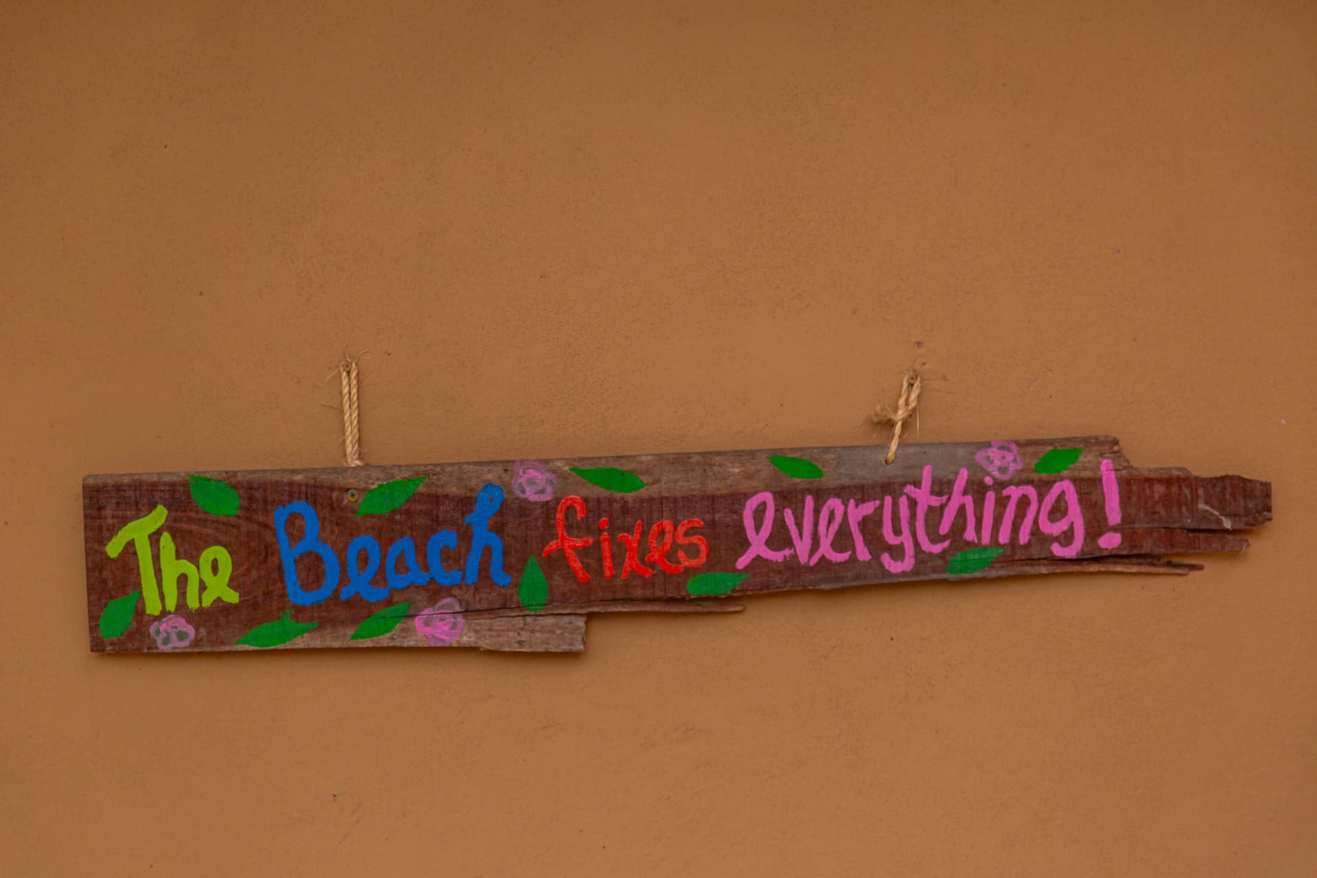 Hand-painted sign reading The Beach fixes everything