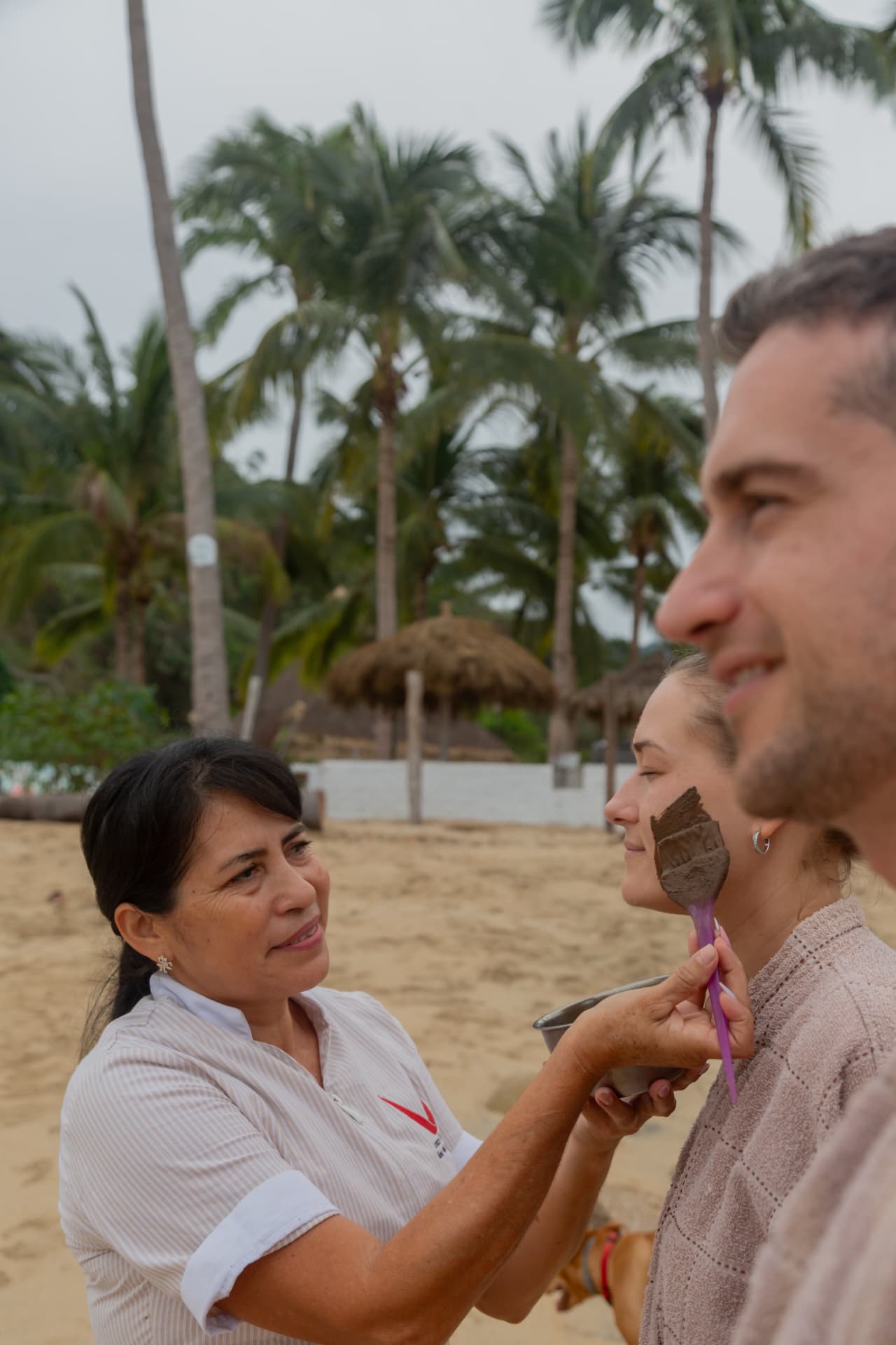 Therapist preparing natural clay under the palm trees