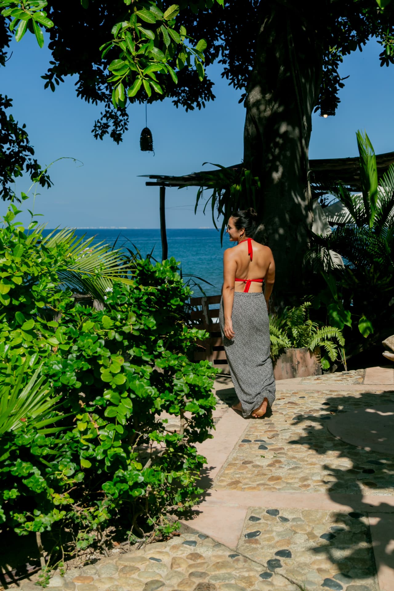 Woman walking the hotel's cobblestone path toward the oceanfront terrace